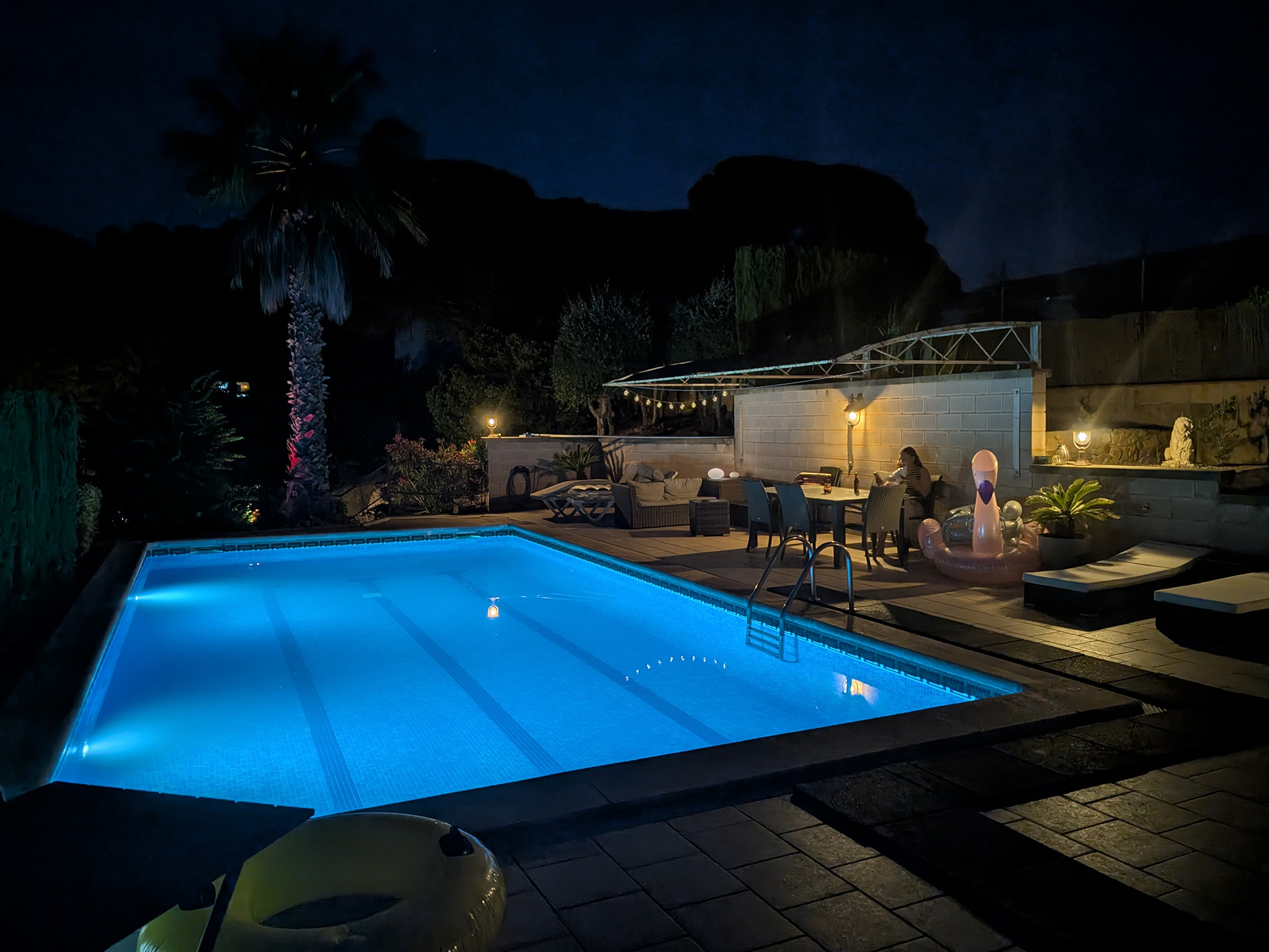 Beleuchteter Pool und Außenbereich bei Nacht